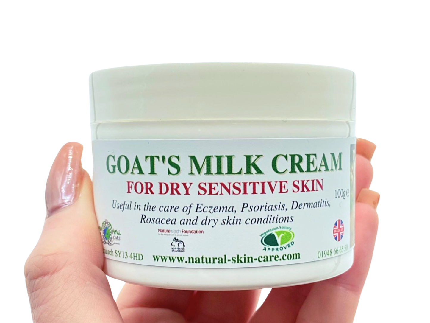 Jar of goat's milk cream for dry sensitive skin held by a hand on a white background